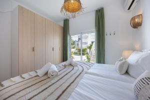 a bedroom with a large white bed with a window at Casa Alvor in Alvor