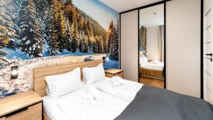 a bedroom with a large painting on the wall at Apartamenty Good Time - Belle View - Centrum in Szklarska Poręba