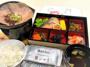 a table with two boxes of food and rice at Ryokan Tanabe 旅館田邊 in Takayama