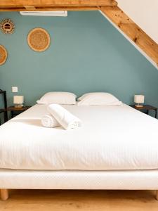 a bedroom with a white bed with two towels on it at Onyx Green in Saint-Aignan