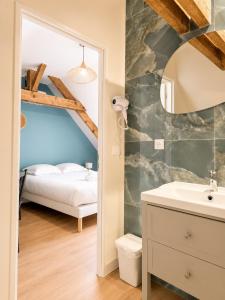 a bathroom with a bed and a sink in a room at Onyx Green in Saint-Aignan