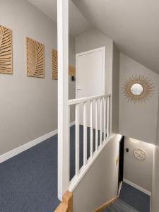 a hallway with a staircase with a mirror at Onyx Green in Saint-Aignan