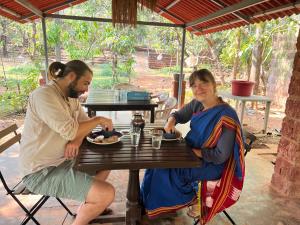 a man and a woman sitting at a table at Atithi Parinay Homestay in Ratnagiri