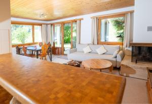 a living room with a couch and a table at Garden apartment with mountain views & barbecue in Lenz +6 photos