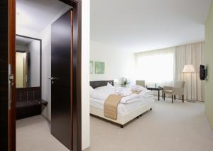 a hotel room with a bed and a bathroom at Heide Spa Hotel & Resort in Bad Düben +33 photos