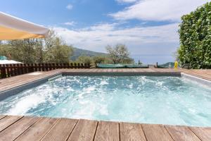 a swimming pool on a wooden deck with the ocean in the background at casa FraLu in Vico Equense