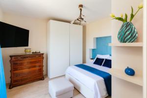 a bedroom with a bed and a dresser with a tv at casa FraLu in Vico Equense +19 photos