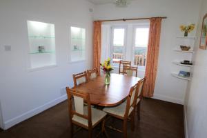 a dining room with a table and chairs and a window at The Lodge Ellary in Lochgilphead
