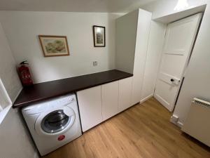 a laundry room with a washing machine in it at The Lodge Ellary in Lochgilphead +3 photos