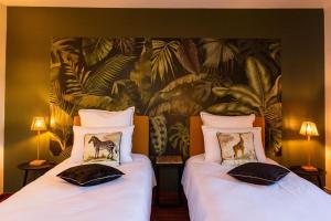 two beds in a room with a painting on the wall at AGAP' & MORPHEE in Pouancé