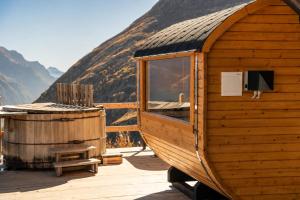 a wooden cabin with a tub on a deck with a mountain at Albergo Ristoro Sitten - 2300 mt in Gressoney-la-Trinité