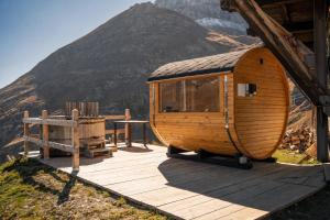 a round wooden cabin with a table and a mountain at Albergo Ristoro Sitten - 2300 mt in Gressoney-la-Trinité