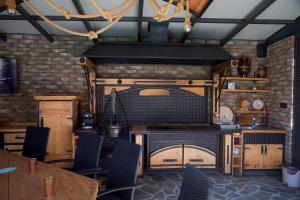 a kitchen with a stove and a table and chairs at Aurum Etno & Spa in Smederevo