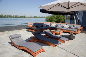 a patio with a couch and chairs and an umbrella at Aurum Etno & Spa in Smederevo