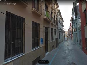 an empty alley in a city with buildings at Galvez Rosa Apartment in Málaga