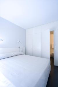 - une chambre blanche avec un grand lit blanc dans l'établissement Residence i MasCa', à Bologne