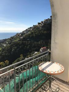 a balcony with a table and a view of the ocean at La Casa Del Nonno Raffaele- Country house in Ravello