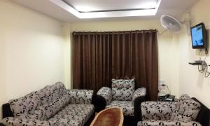 un soggiorno con divano e 2 sedie di Kevins Bed & Breakfast a Port Blair