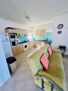 a living room with a couch and a kitchen at Sea View Pool 2BR Esentepe in Kalogrea
