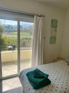 a bedroom with a bed and a sliding glass door at Sea View Pool 2BR Esentepe in Kalogrea +19 photos