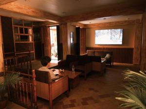 a person sitting in a living room watching a television at Hotel Terracotta in Bhaktapur