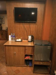 a room with a tv on a wall with a refrigerator at Hotel Terracotta in Bhaktapur