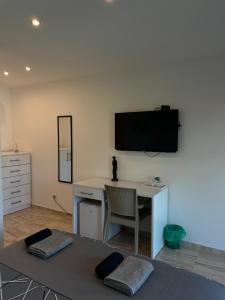 a room with a desk and a tv on the wall at Villa Dimo Topal Luxury Suites with Pool & Jacuzzi in Ohrid