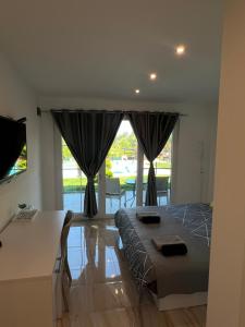 a bedroom with a bed and a large window at Villa Dimo Topal Luxury Suites with Pool & Jacuzzi in Ohrid
