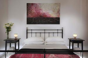 1 dormitorio con 1 cama con 2 mesitas de noche y una pintura en Bernini House, en Roma