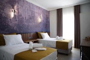 a hotel room with two beds and a purple wall at Quatro Life Hotel in Bodrum City +51 photos