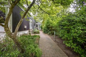 a brick walkway next to a house with trees at Kleine Seeperle in Quickborn