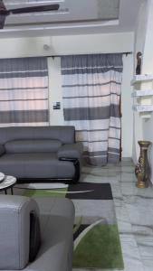 a living room with a couch and a table at Elite Solutions Apartments in Ouéga