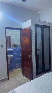 a room with a bathroom with a door and a sink at Elite Solutions Apartments in Ouéga