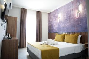 a hotel room with a bed with a purple wall at Quatro Life Hotel in Bodrum City