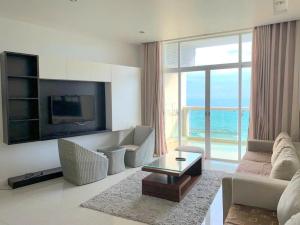a living room with a couch and a tv at Căn Hộ OceanVista & Biệt Thự Sealink Phan Thiết - Mũi Né in Phan Thiet