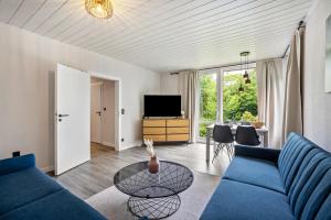 a living room with a blue couch and a table at Kleine Seeperle in Quickborn