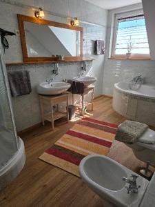 a bathroom with two sinks and a tub and a mirror at Susann Vendégház in Szigetmonostor +36 photos