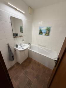 a white bathroom with a tub and a sink at Ubytování u Šimků in Broumov +35 photos
