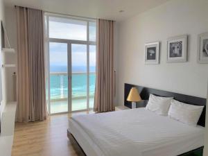 a bedroom with a bed with a view of the ocean at Căn Hộ OceanVista & Biệt Thự Sealink Phan Thiết - Mũi Né in Phan Thiet +61 photos