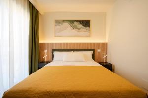 ein Schlafzimmer mit einem großen Bett und einer gelben Decke in der Unterkunft SIGIS HOTEL - Fiumicino in Fiumicino