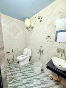 a bathroom with a toilet and a sink at Amba palace in Prayagraj