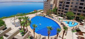 an overhead view of a large swimming pool with palm trees at Bella by the Sea in Sowayma