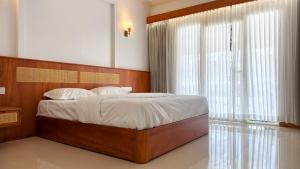 a bedroom with a bed with a wooden headboard and a window at Estate IV - Saffron Suite - Tea Estate Stay in Vythiri