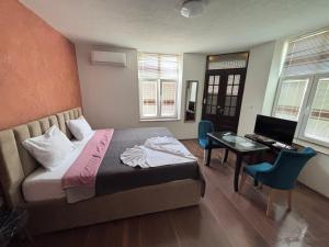 a bedroom with a bed and a desk and a desk at Rooms Filip in Bitola