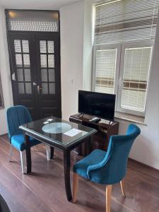 a room with a table and chairs and a desk at Rooms Filip in Bitola