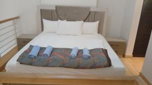 a bed with blue slippers on it in a room at Bella by the Sea in Sowayma +52 photos