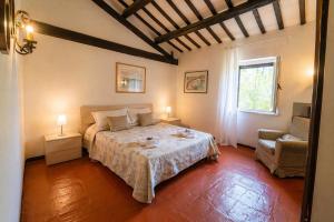 a bedroom with a bed and a chair at Casa Adele - 10 min from the sea! in Carignano