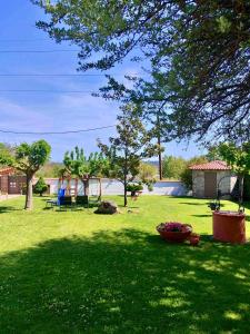 a green yard with a tree and a playground at Forest view evia in Prokópion