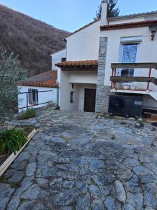 a house with a stone driveway in front of it at la roussette in Prats-de-Mollo-la-Preste