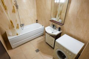 a bathroom with a tub and a sink and a washing machine at Summerland Lake View Apartament in Mamaia +17 photos